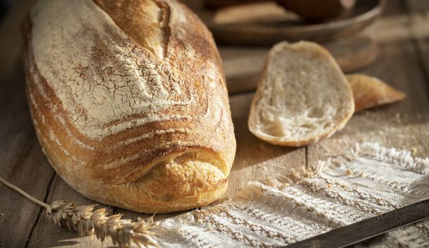 Pan de trigo blanco fresco en una mesa rústica - Foto, Imagen