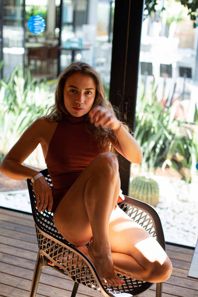 European young white woman sitting with windows behind - 写真・画像