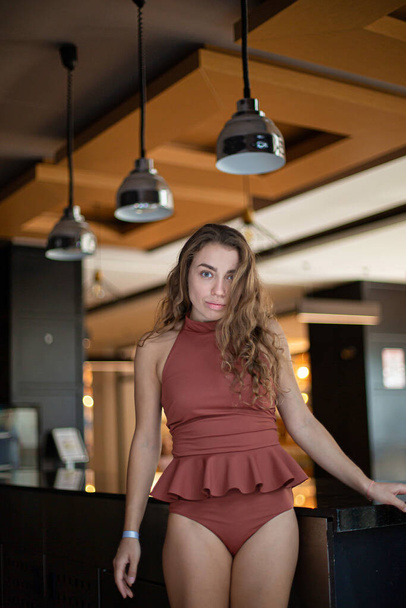 European young woman in swimsuit standing in the restaurant - Photo, Image