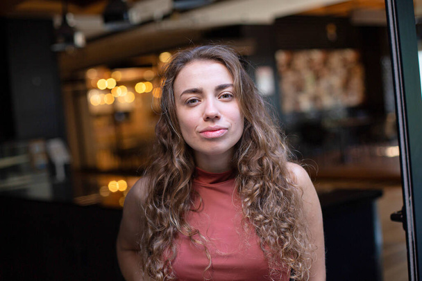 European young woman with dark curly hair in the restaurant portrait - Photo, image