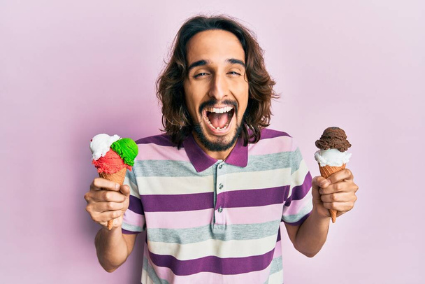 Genç İspanyol adam dondurma tutuyor ve kahkahalarla gülüyor çünkü komik, çılgınca bir şaka..  - Fotoğraf, Görsel