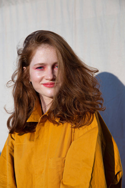 Young european white girl with bright makeup near the wall - Valokuva, kuva