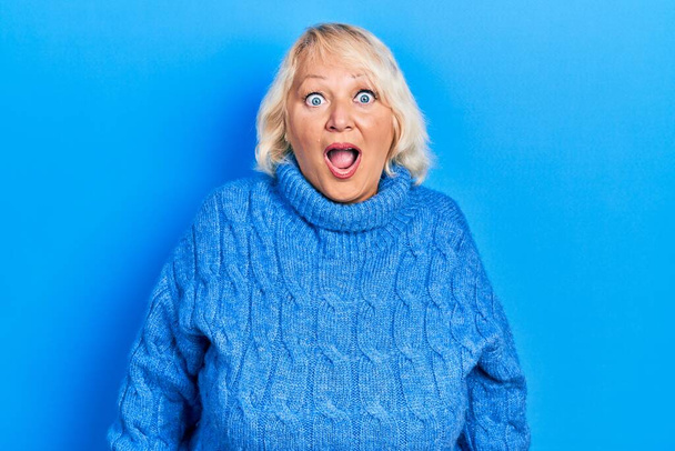Middle age blonde woman wearing casual clothes afraid and shocked with surprise and amazed expression, fear and excited face.  - Photo, Image