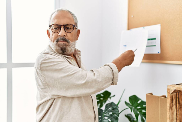 Senior grey-haired man working at office - Foto, imagen