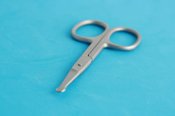 Silver special nail scissors for a baby on a blue surface - Fotó, kép