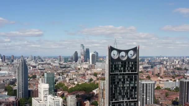 Εμπρός πετούν γύρω από σύγχρονο ουρανοξύστη με ανεμογεννήτριες στο κορυφαίο μέρος της κατασκευής. Αποκαλύπτοντας πανοραμική θέα της πόλης με μια ομάδα από ψηλά κτίρια γραφείων. Λονδίνο, Ηνωμένο Βασίλειο - Πλάνα, βίντεο