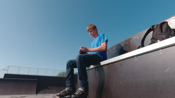 Homem no parque de skate colocando em proteção - Filmagem, Vídeo