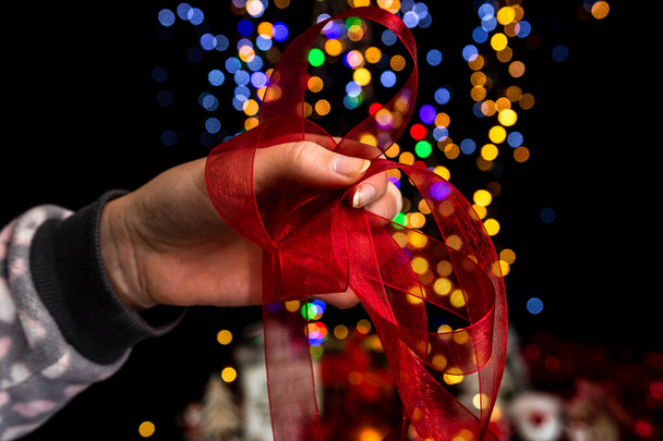 Holding Christmas decoration against bokeh lights background - Foto, immagini