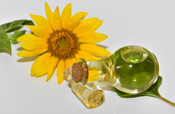 Sonnenblumen- und Sonnenblumenöl auf weißem Hintergrund - Foto, Bild