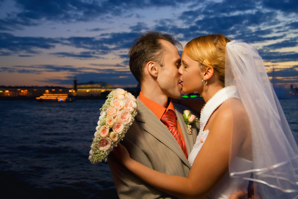 μόλις παντρεμένο ζευγάρι φιλιά κοντά στον ποταμό ηλιοβασίλεμα στιγμή - Φωτογραφία, εικόνα