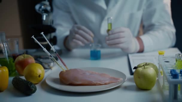 Frisches Gemüse, Obst, Fleisch auf dem Tisch und Wissenschaftler führen Qualitätskontrollen im Labor durch. Gentechnisches Labor. GVO-Lebensmittelkonzept. Injektion in frisches Fleisch. Gentechnik - Filmmaterial, Video