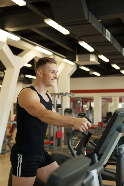 Merry young man exercising on treadmill - Fotografie, Obrázek