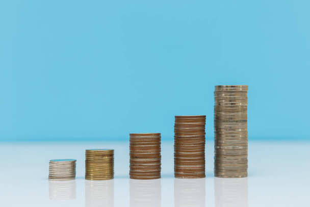 Geld munten stapel blauwe achtergrond, sparen voor de toekomst, investering business concept. - Foto, afbeelding