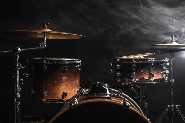 Μέρος ενός drum kit σε μαύρο φόντο, κρουστό όργανο, τύμπανο, τύμπανο μπάσου, hi-hat στη σκηνή κάτω από τους προβολείς. - Φωτογραφία, εικόνα