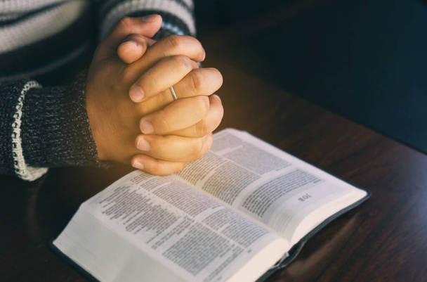 Christian hands while praying and worship for Jesus. We love god. christian people praying while hands worship over a Bible. christian background. freedom. learning religion. - Photo, Image