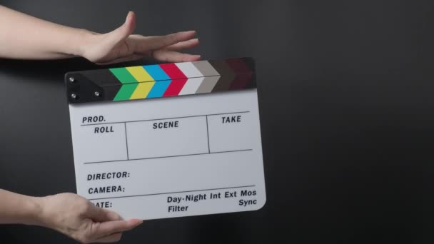 Movie slate or clapperboard hitting. Close up hand holding empty film slate and clapping it on black background. Open and close film slate for video production. film production. Movie shooting. - Footage, Video