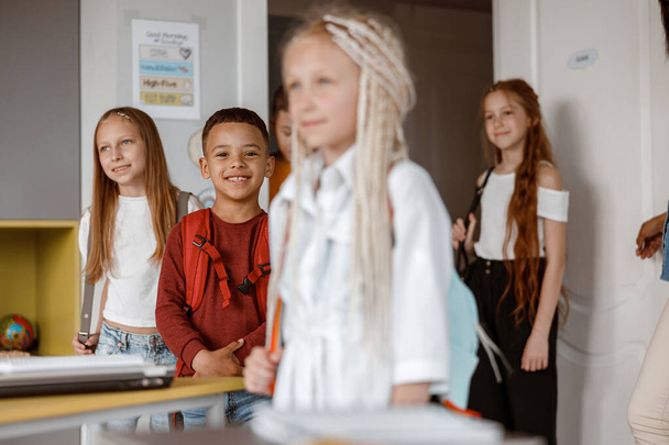 Des enfants souriants debout en classe à l'école - Photo, image