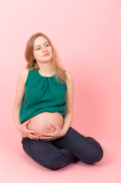 studio portrait of a pregnant woman on a pink background - Photo, Image