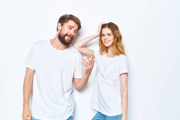 young couple in white t-shirts communication clothes jeans light background - Fotó, kép