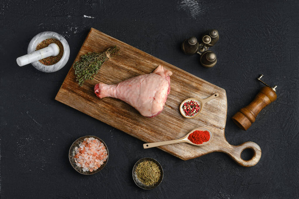 Raw turkey drumstick with skin on wooden board - Foto, afbeelding