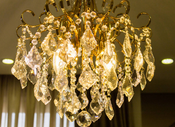 A closeup shot of a brightly glowing, luxurious chandelier in a modern home - Foto, immagini