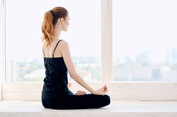 woman doing yoga near the window energy fitness exercise lifestyle - Photo, Image
