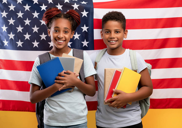 Colegios afroamericanos positivos posando sobre bandera americana - Foto, imagen