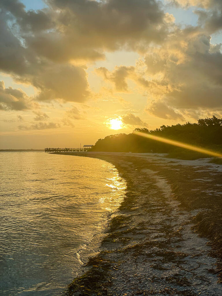 grote oranje zon achter het strand landschap - Foto, afbeelding