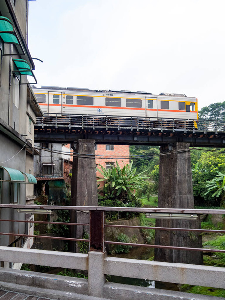Tren de la línea ferroviaria Pingxi que viaja en la antigua calle Pinghsi, Nueva Taipéi, Taiwán - Foto, Imagen