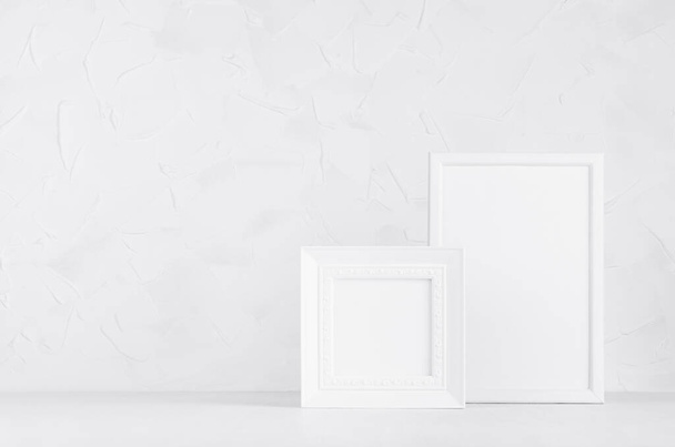Two blank white different wooden frames in delicate soft light minimal modern white interior on wood desk, copy space. Template of exhibition for presentation, portfolio, message, text, design.  - Foto, Imagen