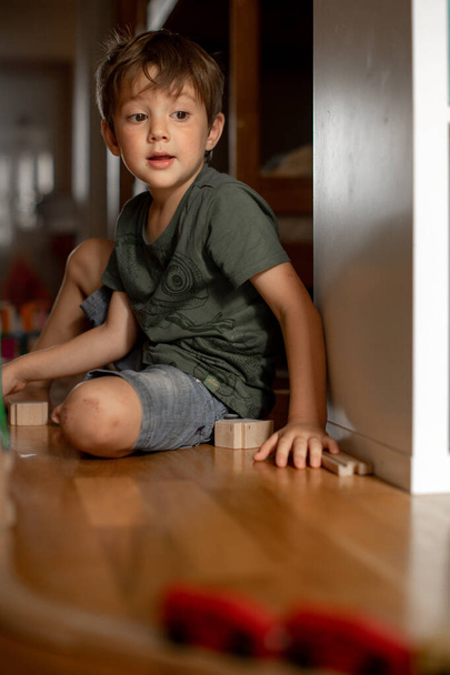 little boy 5 years old playing wooden railroad at home. child playing with toys - Foto, Imagem