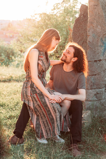 Hipster, romantic couple having fun in the park. Enjoying the afternoon sun. Curly hair boyfriend with long haired girlfriend. - Foto, Imagen