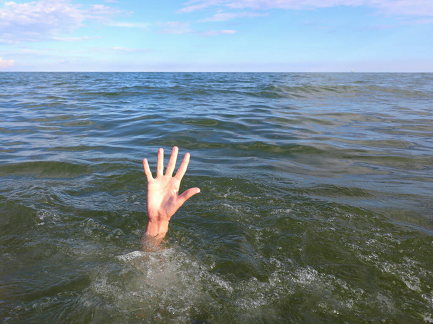 hand of the young man in distress who drowns in the middle of the sea - Photo, Image