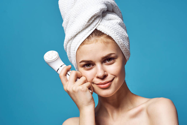 woman with towel on head naked shoulders massager cosmetology skin care - Фото, зображення