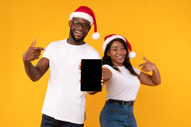 Africano casal mostrando Digital Tablet Screen Publicidade oferta de Natal, Estúdio - Foto, Imagem
