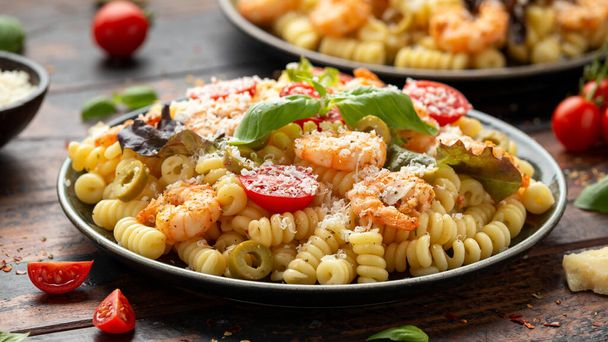 Prawn pasta salad with marinated green olives, cherry tomatoes and parmesan cheese. - Foto, Bild