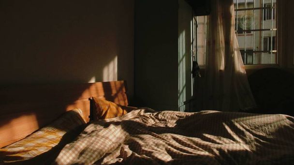 ένα κοντινό πλάνο μιας όμορφης νεαρής γυναίκας ξαπλωμένης σε ένα κρεβάτι με ένα μαξιλάρι και μια κουβέρτα - Φωτογραφία, εικόνα