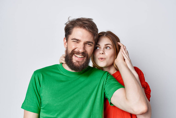 man and woman multicolored t-shirts communication quarrel light background - Zdjęcie, obraz