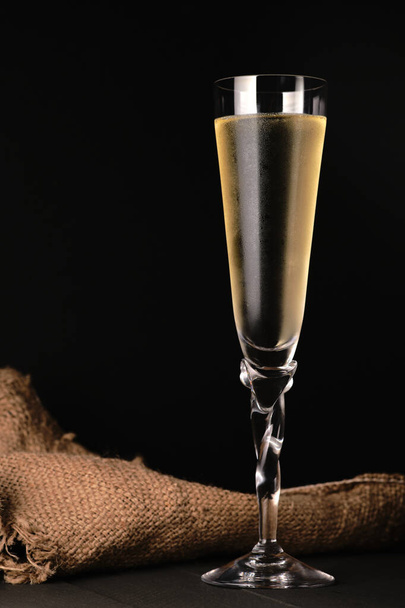 Close-up van champagneglas en zwarte achtergrond.Tekstruimte - Foto, afbeelding