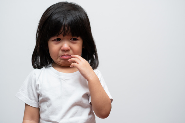 Portret Azjatki rozgniewanej, smutnej i płaczącej dziewczynki na białym, odizolowanym tle, Emocja dziecka, gdy ma napady złości i wściekłości, ekspresja zrzędliwych emocji. Koncepcja kontroli emocjonalnej dziecka - Zdjęcie, obraz