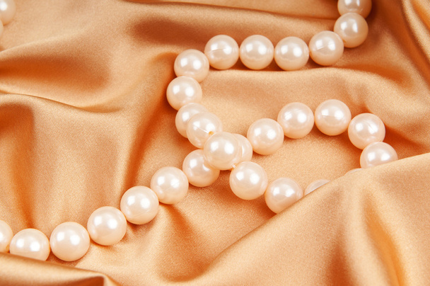 Pearl necklace on the bright satin background - Photo, Image
