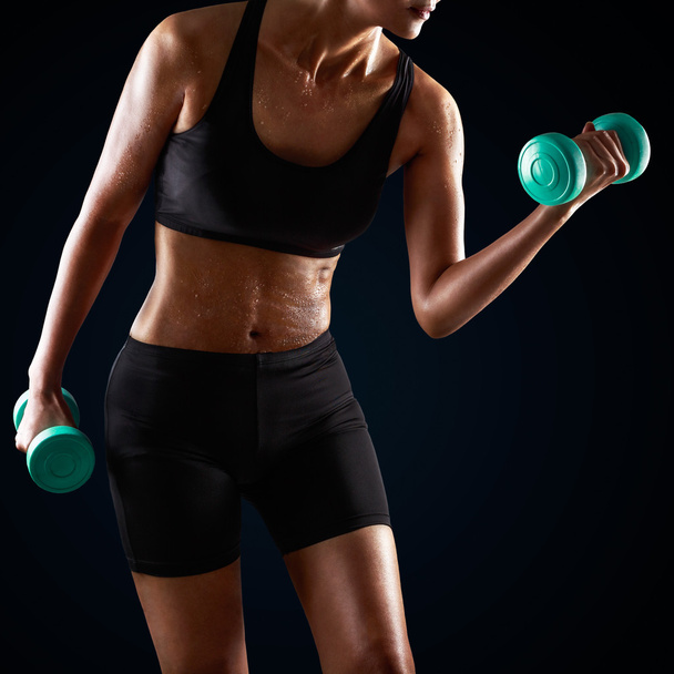 Athletic woman lifting dumbbell - Fotografie, Obrázek