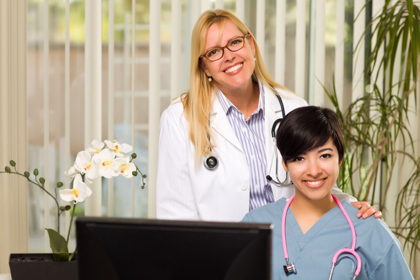 uśmiechnięty mieszanej rasy kobiet lekarze lub pielęgniarki w biurze ustawienie - Zdjęcie, obraz