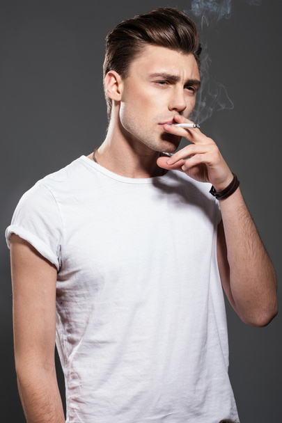 Handsome young man smoking cigarette - Φωτογραφία, εικόνα