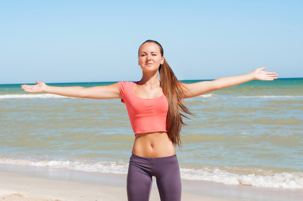 Beautiful girl is engaged in yoga on the beach - Фото, зображення