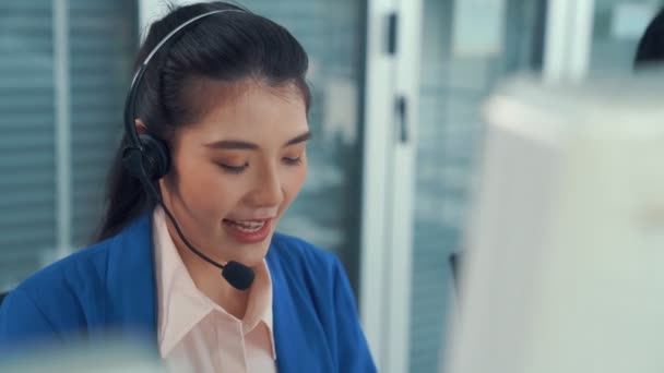 Vezetékes fülhallgatót viselő üzletasszony aktívan dolgozik az irodában - Felvétel, videó