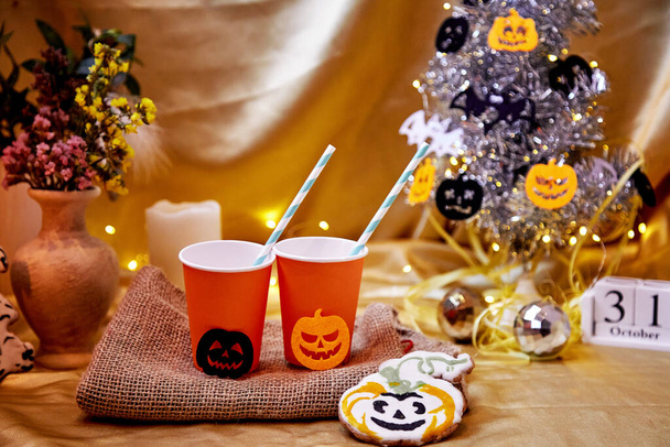 Festive creative Halloween tree party. Halloween atmosphere holidays with candles, cardboard cups and homemade cookies and calendar. Copy space - Photo, Image