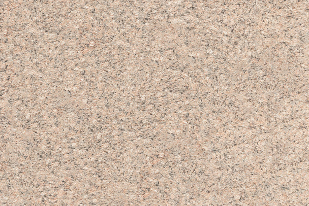 The mottled surface of the granite slab is finely speckled. Uniform texture of natural stone. - Фото, зображення