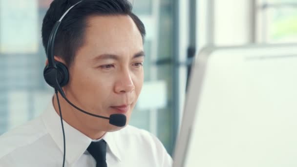 Liikemies yllään kuulokkeet toimivat aktiivisesti toimistossa - Materiaali, video