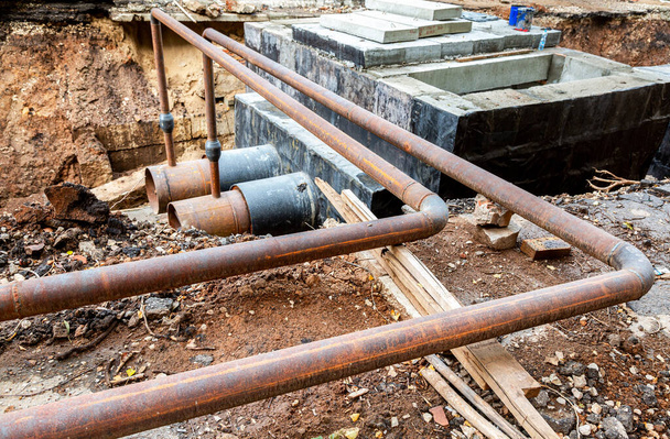 加熱管の交換と加熱システムの近代化。発掘された溝の深さにある大きな鋼管の建設工事 - 写真・画像